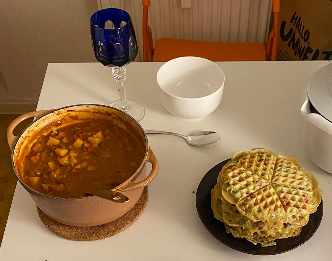 Im Waffeleisen heiß ausgebackene Grumbeerwaffeln, daneben traditionelle Gulaschsuppe im Topf