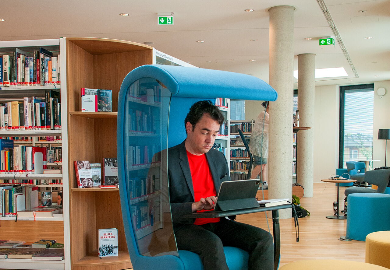 Matthias Warkus arbeitet konzentriert am Laptop in der Ernst-Abbe-Bücherei in Jena